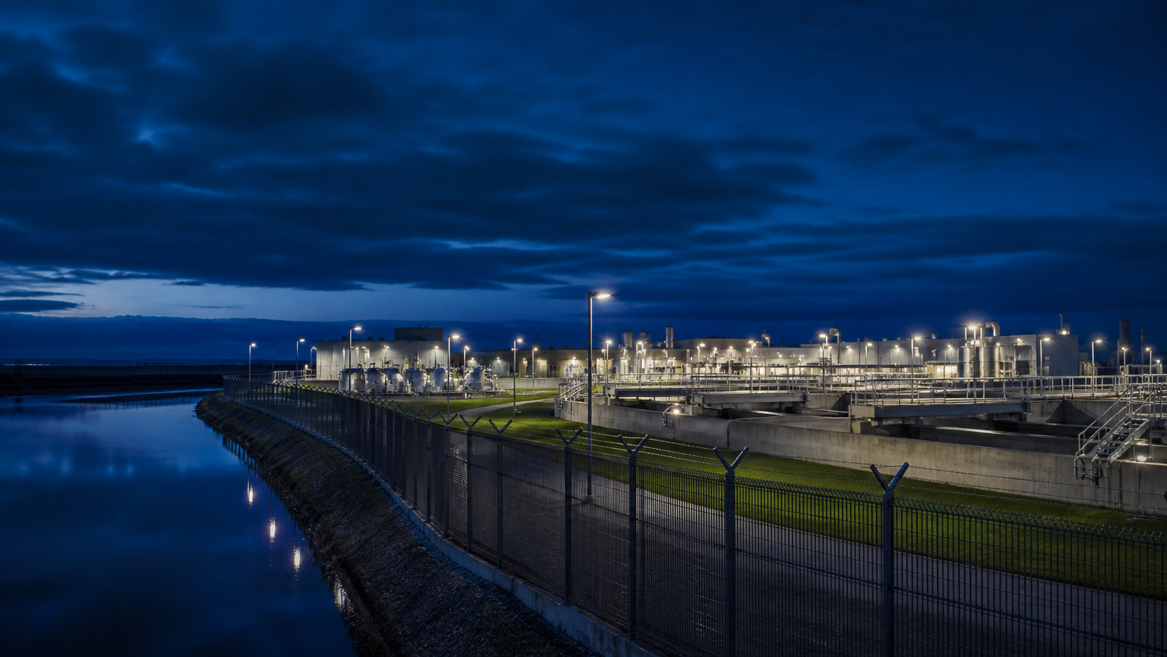 Controlled perimeter surrounding a critical water and utility complex at blue hour